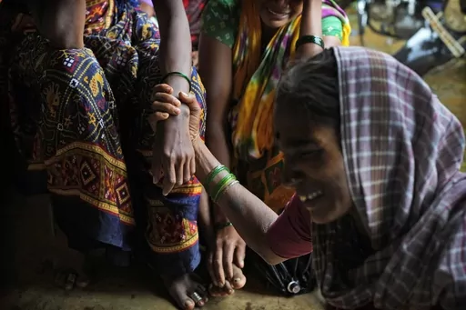 A woman holds the hand of her relative as family members of people trapped under rubble wail after a landslide washed away houses in Raigad district, western Maharashtra state, India, July 20, 2023. The devastation of this year's monsoon season in India, which runs from June to September, has been significant. (AP Photo/Rafiq Maqbool)