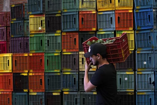 A worker carries a crate of avocados at a plant in Uruapan, Michoacan state, Mexico, Friday, Feb. 9, 2024. A lack of rain and warmer temperatures has resulted in fewer avocados being shipped from Mexico to the United States. (AP Photo/Armando Solis)
