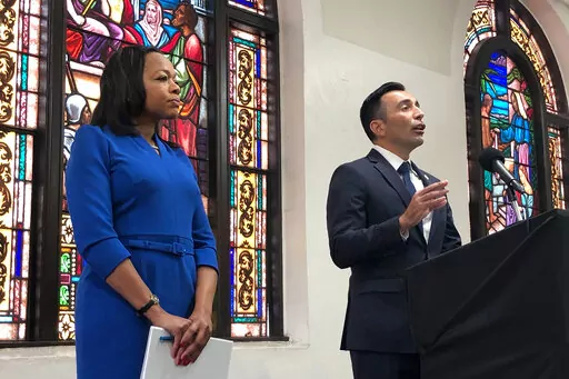 Assistant Attorney General of the U.S. Department of Justice's Civil Rights Division Kristen Clarke, left, listens as United States Attorney Martin Estrada, of the California central division, speaks while announcing the largest redlining case in American history during a news conference Thursday, Jan. 12, 2023, at the Second Baptist Church in Los Angeles. (AP Photo/Stefanie Dazio)