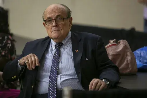Former New York City Mayor Rudy Giuliani sits where delegate votes will be counted as nominee for statewide positions are introduced during the Michigan Republican convention at Devos Place in Grand Rapids, Mich., on Saturday, April 23, 2022. (Daniel Shular/The Grand Rapids Press via AP)