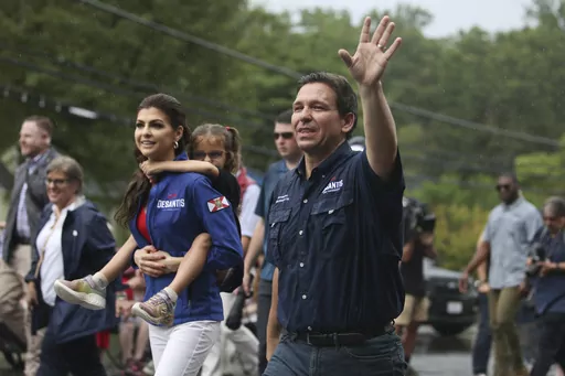 Republican presidential candidate and Florida Gov. Ron DeSantis and his wife Casey, walk in the July 4th parade, Tuesday, July 4, 2023, in Merrimack, N.H. (AP Photo/Reba Saldanha)