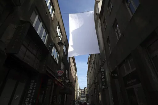 A cloth representing sniper protection screen is displayed in downtown in Sarajevo, Bosnia, Monday, April 4, 2022. Sarajevo is paying a subdued tribute to the resilience of its citizens who survived the longest military siege in modern history, and commemorating thousands of others who did not. Many of the survivors said they found the 30th anniversary of the start of the siege of the Bosnian capital particularly hard because they are marking it against the backdrop of what they describe as simi