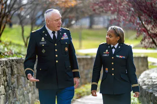Head National Guard chaplain Col. Larry Bazer, deputy director of the chaplain office, left, and Chaplain Maj. A'Shellarien Lang, right, speak at the National Guard Bureau in Arlington, Va., Friday, Dec. 17, 2021. (AP Photo/Andrew Harnik)