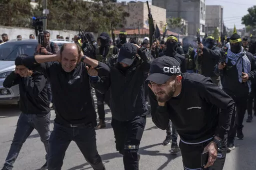 Palestinian gunmen shoot in the air during the funerals for Sanad Abu Atiyeh, 17 and Yazid al-Saadi, 23, in the West Bank refugee camp of Jenin, Jenin, Thursday, March 31, 2022. Israeli forces raided a refugee camp in the occupied West Bank early Thursday, setting off a gun battle in which two Palestinians were killed and 15 were wounded, the Palestinian Health Ministry said. (AP Photo/Nasser Nasser)
