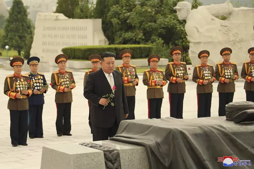 In this photo provided by the North Korean government, North Korean leader Kim Jong Un, foreground, prepares to offer a flower at a liberation war martyrs cemetery in Pyongyang, North Korea Tuesday, July 25, 2023, on the occasion of the 70th anniversary of the armistice that halted fighting in the 1950-53 Korean War. Independent journalists were not given access to cover the event depicted in this image distributed by the North Korean government. The content of this image is as provided and cann