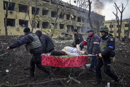 Ukrainian emergency employees and volunteers carry an injured pregnant woman from a maternity hospital that was damaged by shelling in Mariupol, Ukraine, March 9, 2022. The woman and her baby died after Russia bombed the maternity hospital where she was meant to give birth. (AP Photo/Evgeniy Maloletka, File)