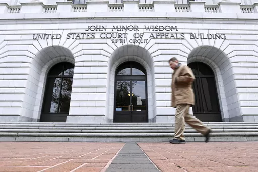 A man walks in front of the 5th U.S. Circuit Court of Appeals, Jan. 7, 2015, in New Orleans. In a Thursday, Jan. 4, 2024, ruling, the U.S. 5th Circuit Court of Appeals denied the NAACP's motions for an injunction pending appeal and vacated an administrative stay that had temporarily blocked state officials from creating the court. (AP Photo/Jonathan Bachman, File)