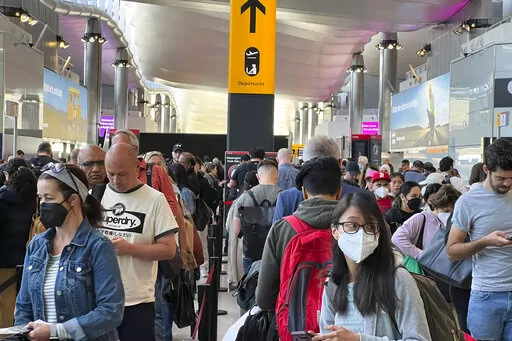 Travellers queue at security at Heathrow Airport in London, Wednesday, June 22, 2022. London’s Heathrow Airport  apologized Monday, July 11, 2022 to passengers whose travels have been disrupted by staff shortages. The airport warned that it may ask airlines to cut more flights from their summer schedules to reduce the strain if the chaos persists. (AP Photo/Frank Augstein, File)