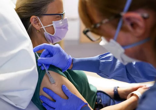 Registered nurse Erika Obrietan administers the third dose of an experimental breast cancer vaccine to patient Kathleen Jade at University of Washington Medical Center - Montlake, Tuesday, May 30, 2023, in Seattle. Jade, 50, learned she had breast cancer in late February. She's getting the vaccine to see if it will shrink her tumor before surgery. “Even if that chance is a little bit, I felt like it’s worth it," said Jade, who is also getting standard treatment. (AP Photo/Lindsey Wasson)