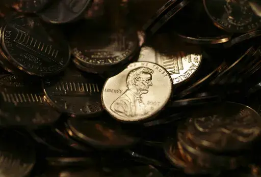A lone penny is illuminated in a bin of completed pennies at the U.S. Mint in Denver, Aug. 15, 2007. (AP Photo/David Zalubowski)