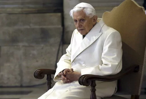 Pope Emeritus Benedict XVI sits in St. Peter's Basilica as he attends the ceremony marking the start of the Holy Year, at the Vatican, Dec. 8, 2015. A long-awaited report on the church's handling of cases of sexual abuse by clergy and others in Germany's Munich archdiocese and which was once led by retired Pope Benedict XVI from 1977 until 1982, is being released on Thursday Jan. 20, 2022. (AP Photo/Gregorio Borgia, File)
