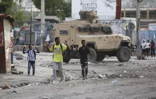 Youths raise their hands to show police they are not carrying weapons during an anti-gang operation at the Portail neighborhood in Port-au-Prince, Haiti, Thursday, Feb. 29, 2024. (AP Photo/Odelyn Joseph)