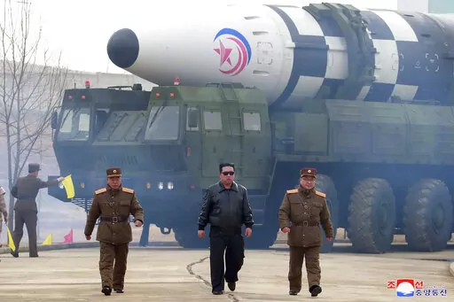 In this photo distributed by the North Korean government, North Korean leader Kim Jong Un, center, walks around what it says a Hwasong-17 intercontinental ballistic missile (ICBM) on the launcher, at an undisclosed location in North Korea on March 24, 2022. Independent journalists were not given access to cover the event depicted in this image distributed by the North Korean government. The content of this image is as provided and cannot be independently verified. Korean language watermark on im
