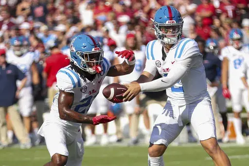 Mississippi quarterback Jaxson Dart (2) hands the ball off to running back Henry Parrish Jr. (21) during the first half of an NCAA college football game against South Carolina Saturday, Oct. 5, 2024, in Columbia, S.C. (AP Photo/Artie Walker Jr.)
