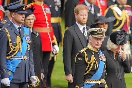 King Charles III, from right, Camilla, the Queen Consort, Meghan, Duchess of Sussex, Prince Harry and Prince William watch as the coffin of Queen Elizabeth II is placed into the hearse following the state funeral service in Westminster Abbey in central London on Sept. 19, 2022. Prince Harry has said he wants to have his father and brother back and that he wants “a family, not an institution” during a TV interview ahead of the publication of his memoir. The interview with Britain's ITV channe