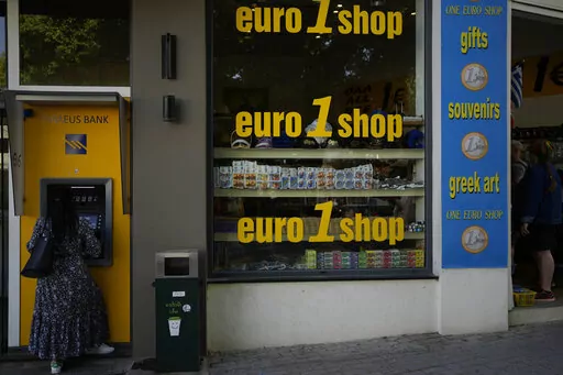 A woman uses an ATM machine in the main town of the Aegean Sea island of Rhodes, southeastern Greece, Tuesday, May 10, 2022.  Inflation in 19 European countries using the euro currency hits another record at 10% as energy prices soar. (AP Photo/Thanassis Stavrakis, File)