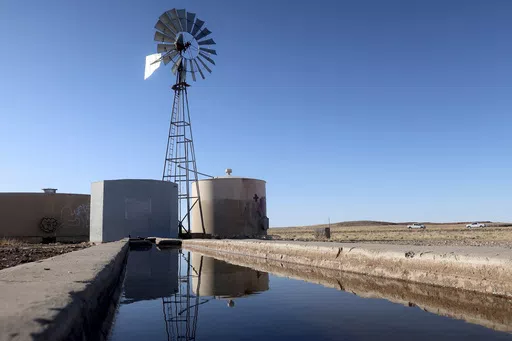 A windmill draws water for livestock in Leupp, Ariz., on the Navajo Nation, Saturday, March 9, 2024. In a vote on Thursday, May 23, 2024, the Navajo Nation Council has unanimously approved a proposed water rights settlement that carries a price tag larger than any such agreement enacted by Congress. (AP Photo/Felicia Fonseca, File)