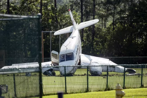 A small plane sits in a field behind the Ocean Springs Middle School in Ocean Springs, Miss., Friday, June 23, 2023, after crashing upon takeoff from the Ocean Springs Airport. (Hannah Ruhoff/The Sun Herald via AP)