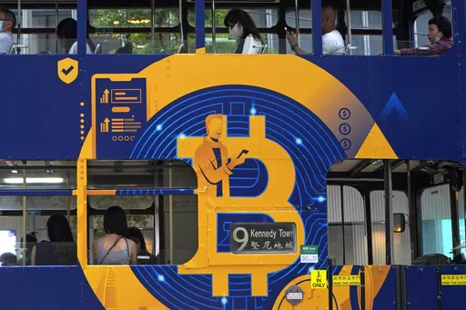 An advertisement for the cryptocurrency Bitcoin displayed on a tram, May 12, 2021, in Hong Kong. Sometime in the next few days or even hours, the “miners” who chisel bitcoins out of complex mathematics are going to take a 50% pay cut — effectively slicing new emissions of the world’s largest cryptocurrency in an event called bitcoin halving. (AP Photo/Kin Cheung, File)
