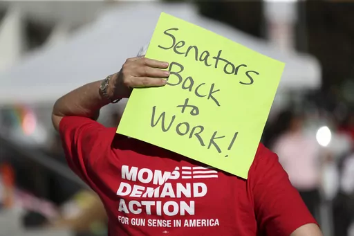An attendee holds a sign behind their head during a rally calling for an end to the Senate Republican walkout at the Oregon State Capitol in Salem, Ore., May 11, 2023. Republicans and an independent senator in the Oregon Senate stretched a walkout Monday, May 15, to 10 days, triggering a new constitutional provision that prohibits lawmakers with 10 or more unexcused absences from being reelected. The walkout that began May 3 has stalled action on hundreds of bills, including on gun control, gend