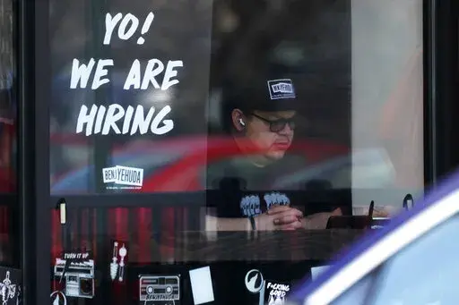 A hiring sign is displayed at a restaurant in Schaumburg, Ill., Friday, April 1, 2022.  More Americans applied for jobless benefits last week, reported Thursday, Aug. 4, 2022,  as the number of unemployed continues to rise modestly, though the labor market remains one of the strongest parts of the U.S. economy.   (AP Photo/Nam Y. Huh, File)