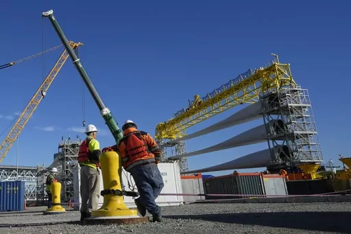 A generator and its blades are prepared to head to the open ocean for the South Fork Wind farm from State Pier in New London, Conn., Dec. 4, 2023. On Thursday, the government issues the first of three estimates of GDP growth in the United States during the October-December quarter.(AP Photo/Seth Wenig, File)