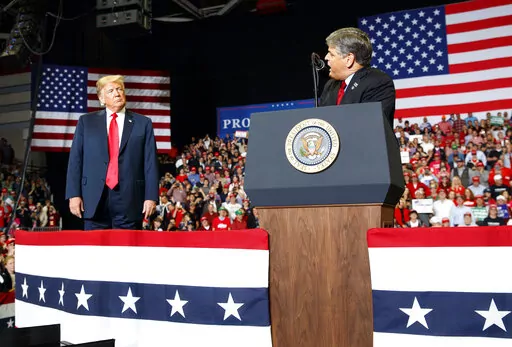 President Donald Trump listens Fox News' Sean Hannity speak during a rally on Nov. 5, 2018, in Cape Girardeau, Mo. The House committee investigating the Jan. 6 U.S. Capitol insurrection has requested an interview and information from Hannity. (AP Photo/Carolyn Kaster, File)