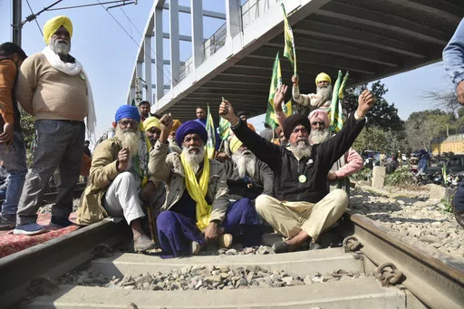 Protesting Indian farmers shout slogans sitting on train tracks as they demand guaranteed prices for their produce at Vallah village, outskirts of Amritsar, Punjab, India, Thursday, Feb.15, 2024. The farmers are also pressing the government to follow through on its promise to double their income, waive their loans and withdraw legal cases brought against them during earlier 2021 protests, when they camped on the capital’s outskirts to demonstrate against controversial agriculture laws. (AP Pho