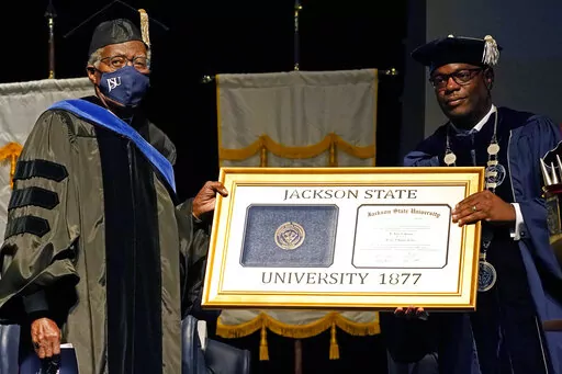 FILE _ Jackson State University Thomas K. Hudson, right, presidents an honorary degree to JSU president emeritus John A Peoples Jr. on Oct. 28, 2021, in Jackson, Miss. The board that governs Mississippi's eight public universities put Hudson on paid administrative leave on Thursday, March 2, 2023, and named Elaine Hayes-Anthony as temporary acting president. (AP Photo/Rogelio V. Solis, File