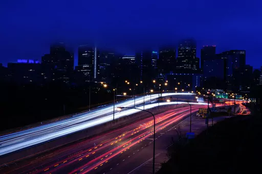 In this photo made with a long exposure, vehicles move along Interstate 76 ahead of the Thanksgiving Day holiday in Philadelphia, Nov. 22, 2023. A big explanation for the recent decline in gas prices is seasonality — with prices at the pump almost always easing at this time of year. (AP Photo/Matt Rourke, File)