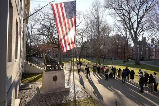 People take photos near a John Harvard statue, left, on the Harvard University campus, Tuesday, Jan. 2, 2024, in Cambridge, Mass. On Wednesday, Jan. 10, several Jewish students filed a lawsuit against Harvard University, accusing it of becoming “a bastion of rampant anti-Jewish hatred and harassment.” (AP Photo/Steven Senne, File)