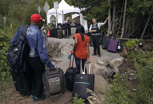 A Royal Canadian Mounted Police officer informs a migrant couple of the location of a legal border station, shortly before they illegally crossed from Champlain, N.Y., to Saint-Bernard-de-Lacolle, Quebec, using Roxham Road. Canada’s government is reimposing some visa requirements on Mexican nationals visiting Canada, an official familiar with the matter told The Associated Press on Wednesday, Feb. 28, 2024. Quebec’s premier has been urging the federal government to slow the influx of refugee