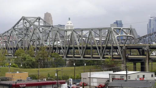 Traffic on the Brent Spence Bridge passes in front of the Cincinnati skyline while crossing the Ohio River to and from Covington, Ky., Oct. 7, 2014. According to a recent announcement by Kentucky and Ohio they will receive more than $1.63 billion in federal grants to help build a new Ohio River bridge near Cincinnati and improve the existing overloaded span there, a heavily used freight route linking the Midwest and the South. (AP Photo/Al Behrman, File)