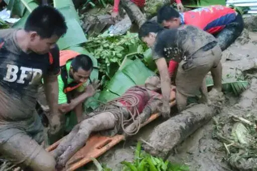 In this photo provided by the Philippine Coast Guard, a man is carried after being rescued from a landslide at Baybay City, Leyte province, central Philippines Monday April 11, 2022. Heavy rains caused by a summer tropical depression killed at least several people in the central and southern Philippines, mostly due to landslides, officials said Monday. (Philippine Coast Guard via AP)