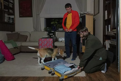 Yaroslav Vedmid, centre and his wife Olena check their luggage in a village during a blackout on the outskirts of Kyiv, Ukraine, Thursday, Oct. 27, 2022. Russian attacks on Ukraine's energy infrastructure have triggered power cuts across the country since early October. Rolling blackouts are increasing across Ukraine as the government rushes to stabilise the energy grid and repair the system ahead of winter. (AP Photo/Andrew Kravchenko)