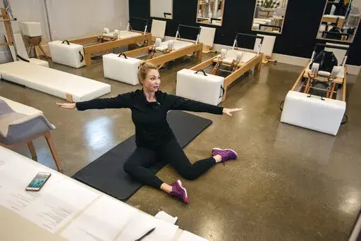 Sarah Burton, owner of Studio B Pilates + Barre leads a Zoom-based live dance conditioning class at her studio in Tyler, Texas, April 4, 2020. A new poll shows that many Americans don't expect to rely on the digital services that became commonplace during the pandemic after COVID-19 subsides. (Sarah A. Miller/Tyler Morning Telegraph via AP)