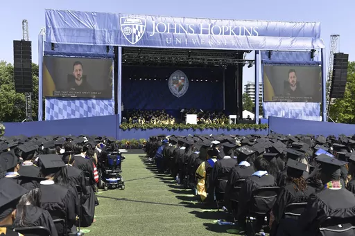 In this handout photo released by Johns Hopkins University, Ukrainian President Volodymyr Zelenskyy addresses the graduating class of Johns Hopkins University via livestream from Ukraine, Thursday, May 25, 2023, in Baltimore, Md. (Will Kirk/Johns Hopkins University via AP)