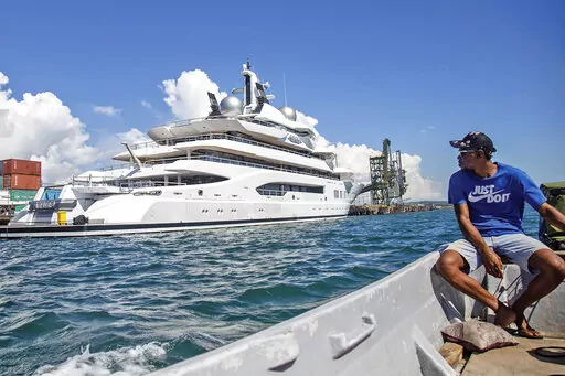 Boat captain Emosi Dawai looks at the superyacht Amadea where it is docked at the Queens Wharf in Lautoka, Fiji, on April 13, 2022. On May 5, five U.S. federal agents boarded the massive Russian-owned superyacht Amadea that was berthed in Lautoka harbor in Fiji in a case that is highlighting the thorny legal ground the U.S. is finding itself on as it tries to seize assets of Russian oligarchs around the world. (Leon Lord/Fiji Sun via AP, File)