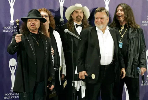 The band Lynyrd Skynyrd, from left, Gary Rossington, Billy Powell, Artimus Pyle, Ed King and Bob Burns appear backstage after being inducted at the Rock and Roll Hall of Fame in New York on March 13, 2006. Rossington, the iconic band's last surviving cofounder, who died Sunday, March 5, was also perhaps the last flag pole in a once powerful part of American culture: Southern rock. (AP Photo/Stuart Ramson, File)