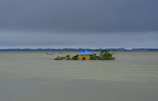 A house stands surrounded by floodwaters in Sylhet, Bangladesh, Monday, June 20, 2022. Early and strong monsoon rains have brought heavy flooding to northeastern India and Bangladesh, killing dozens of people, forcing hundreds of thousands from their homes and cutting millions off from crucial supplies. (AP Photo/Mahmud Hossain Opu)
